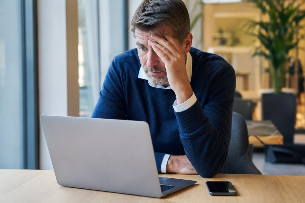 Mann sitzt nachdenklich vor einem Laptop, während er über die Frage „mein Job wird durch KI ersetzt“ und seine berufliche Zukunft nachdenkt